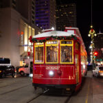 Streetcars and festive holiday lights are part of the holiday magic on Canal Street in New Orleans.